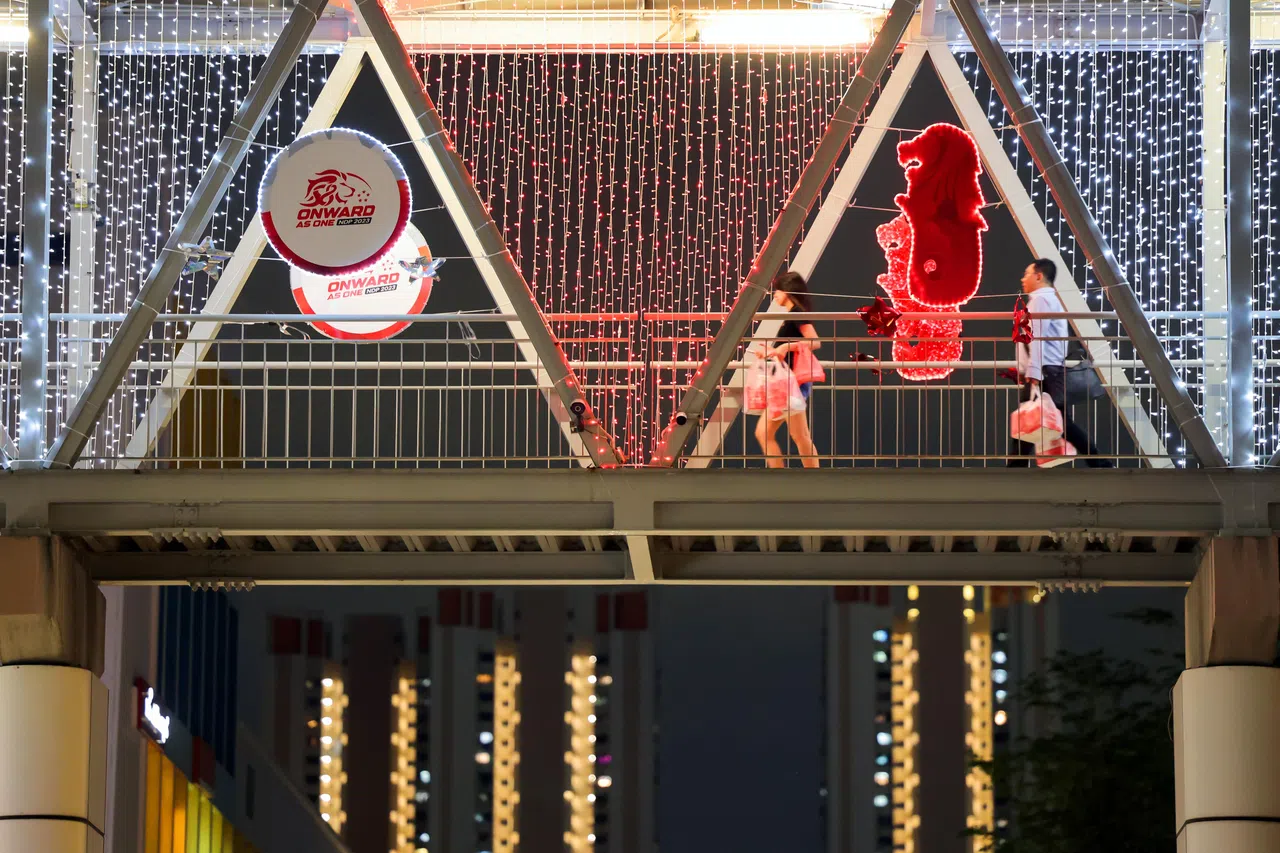 今年的国庆标志由狮头、五星和“58”组成，连同鱼尾狮标志在大巴窑中心并排悬挂，在后方镜子和灯光的衬托下更加熠熠生辉。（李冠卫摄）