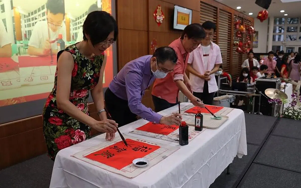 校长们现场为学生们提笔书写新年祝福。（周文靖摄）