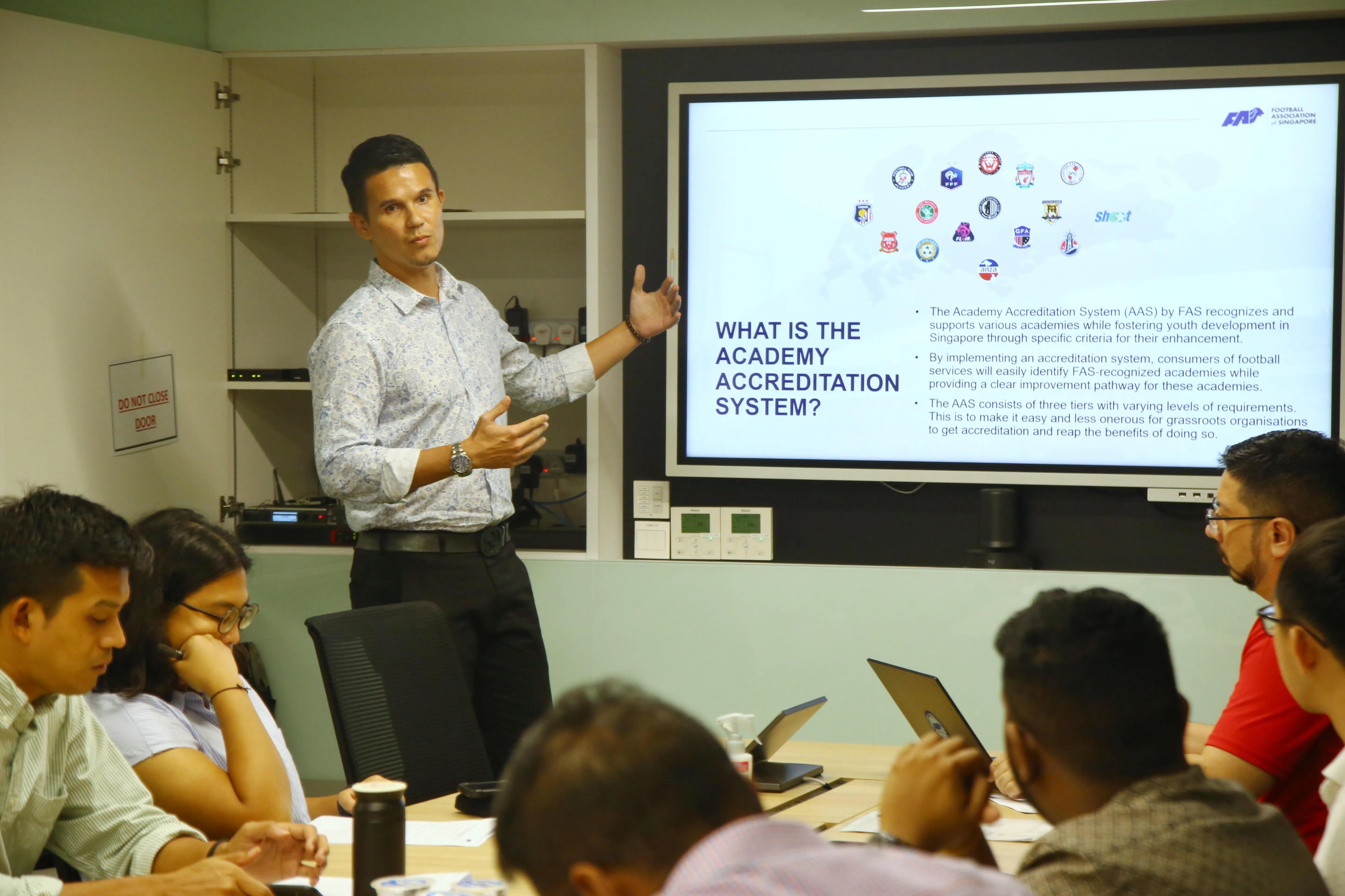 拜哈基向记者介绍足球学院认证系统的机制。（特约陈福洲摄）