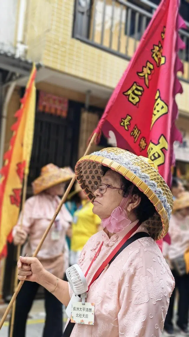 戴着竹笠、身穿传统服饰的渔村妇女造型队员，为巡游增添浓厚本土文化色彩。（陈爱薇摄）