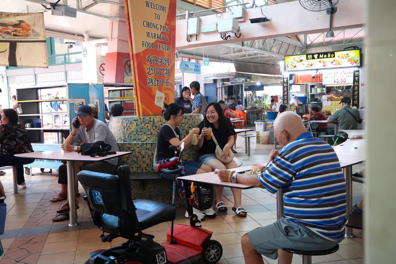 覃竖荑（左）与黄佳韵（右）在忠邦巴刹与熟食中心享用甘蔗水，覃竖荑觉得这里有许多“宝藏”美食。（关俊威摄）