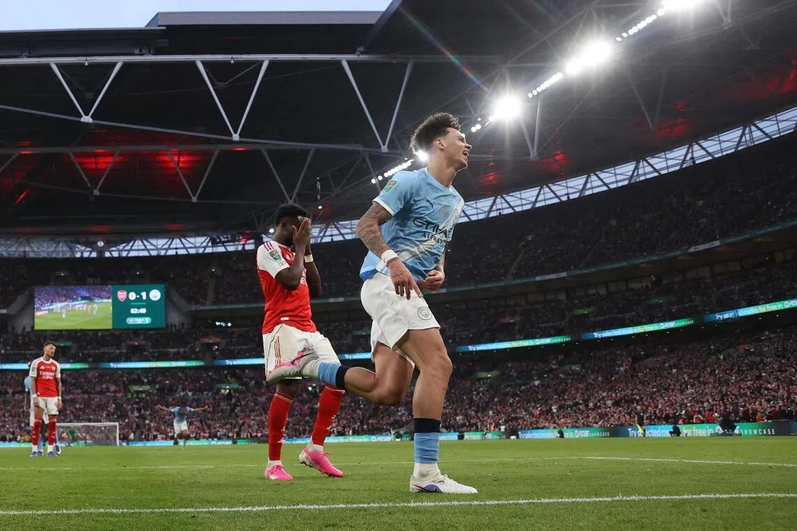 在联赛杯决赛中，曼市小将奥赖利（蓝衣）在四分钟内完成梅开二度，让沦为背景板的萨卡（中红衣）沮丧不已。（路透社）