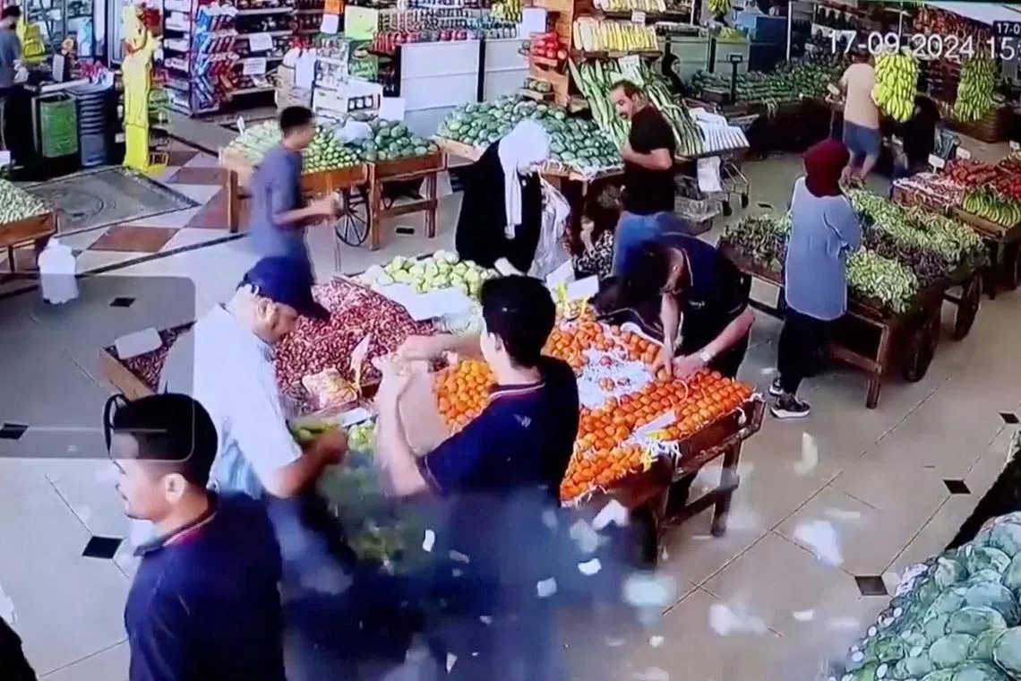 9月17日的社交媒体视频截图显示，黎巴嫩首都贝鲁特一家超市内一名男子的包包爆炸。（路透社）
