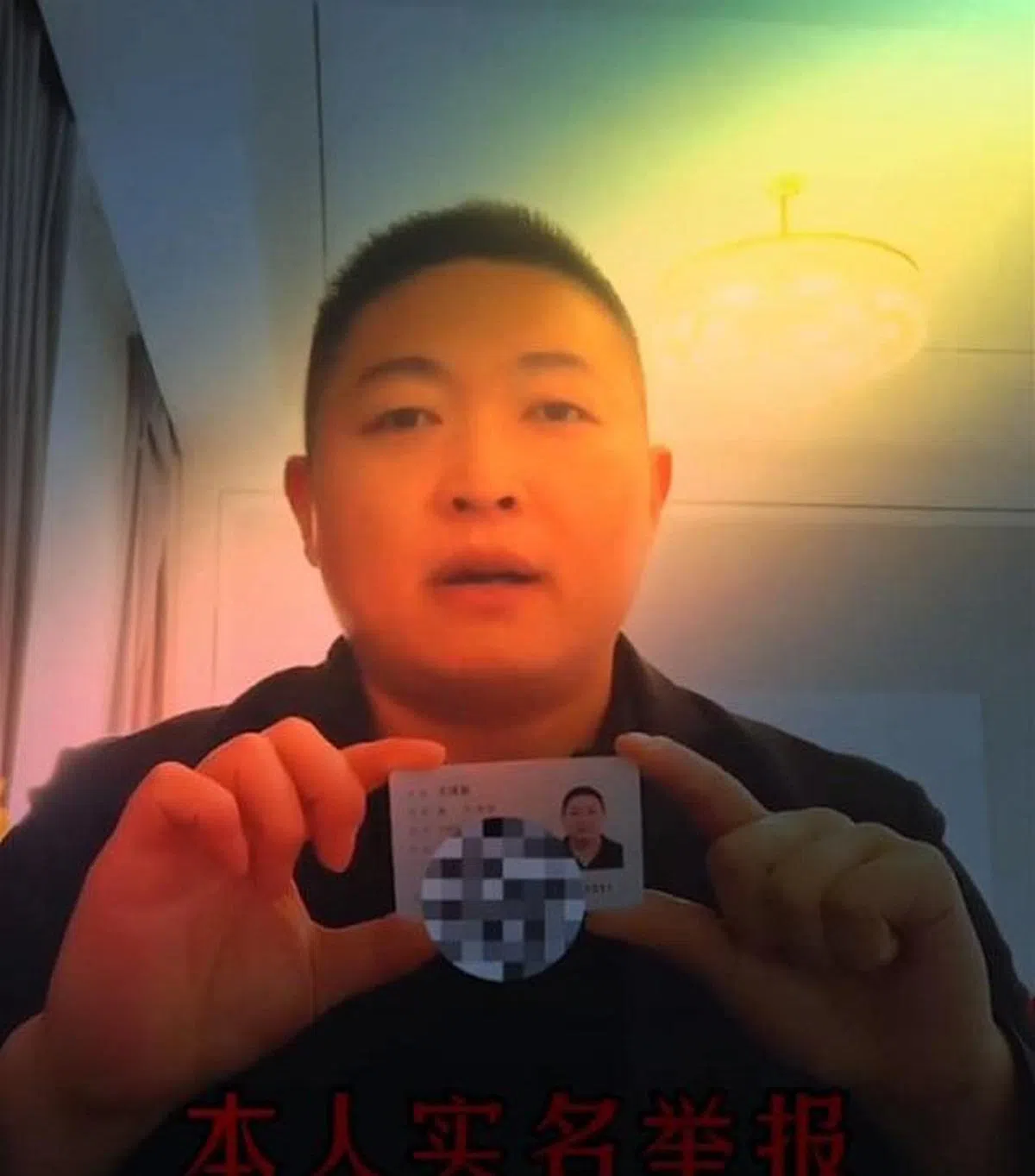 这位中国网民自录视频，拿着身份证实名举报张信哲。（新浪网）