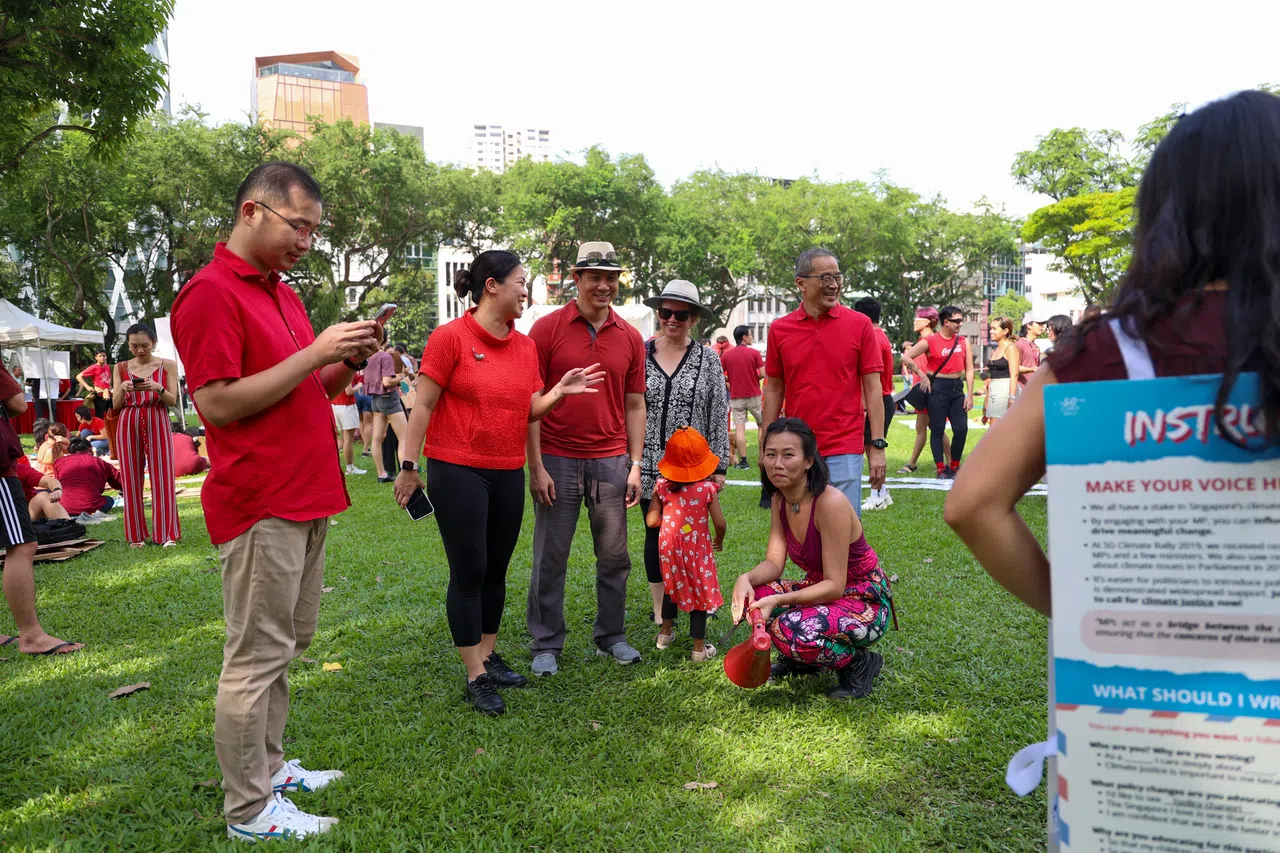 工人党议员蔡庆威（左起）何廷儒、林志蔚，以及陈立峰（右一）在集会现场与公众互动。（关俊威摄）
