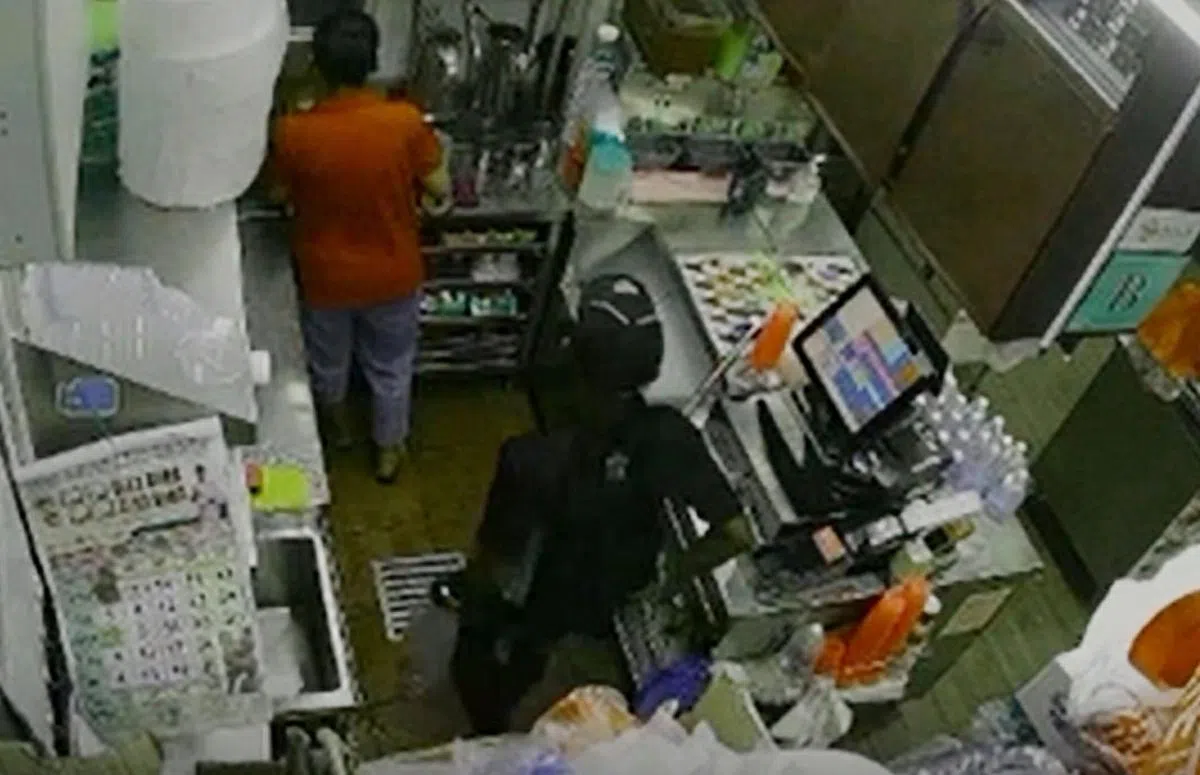 男子走入摊位，顺手偷走手机。（受访者提供）