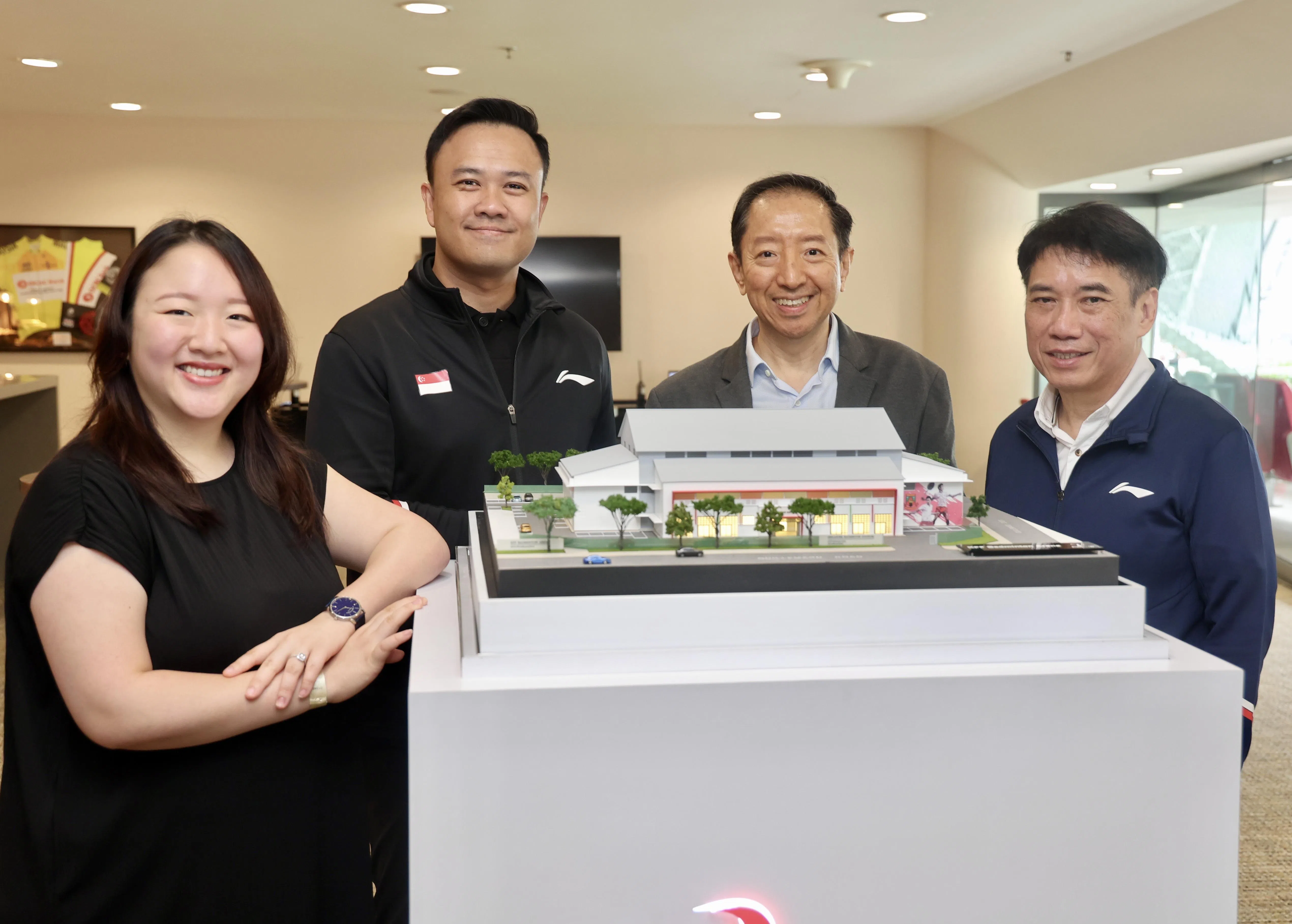 林氏家族基金主要管理人林婉怡（左起），新加坡羽毛球总会总裁欧振统，杰特科术执行董事汪佑任和羽毛球总会会长廖振兴，在全新羽毛球馆模型旁合影。（邬福梁摄）