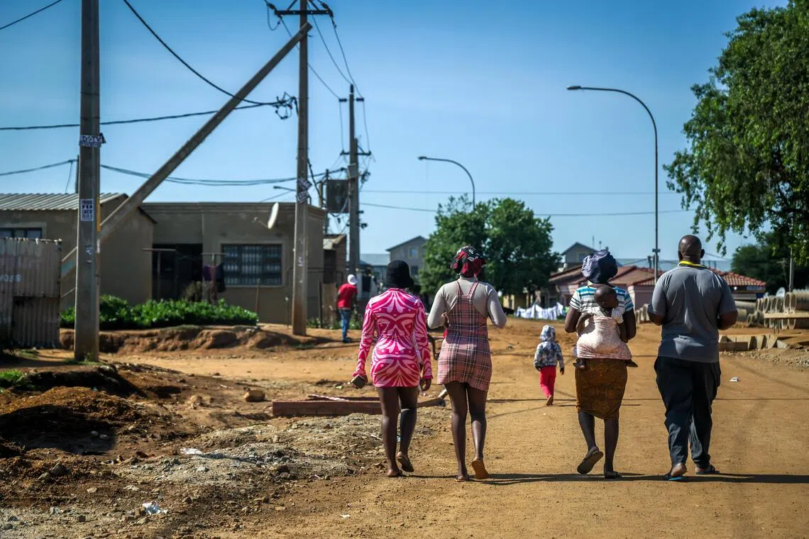 索韦托居民走在尘土飞扬的街道上。（叶振忠摄）