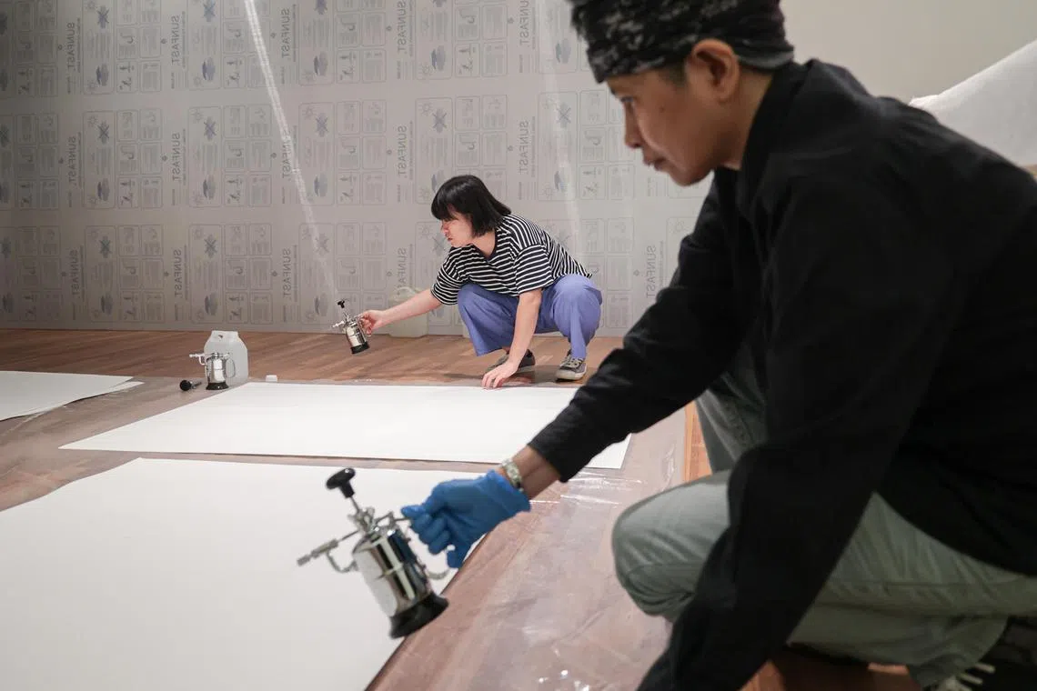 修复团队对《猿》做加湿处理，在画作上铺上多层湿布和湿纸，再加盖一层大塑料布，然后静置几个小时。（李冠卫摄）