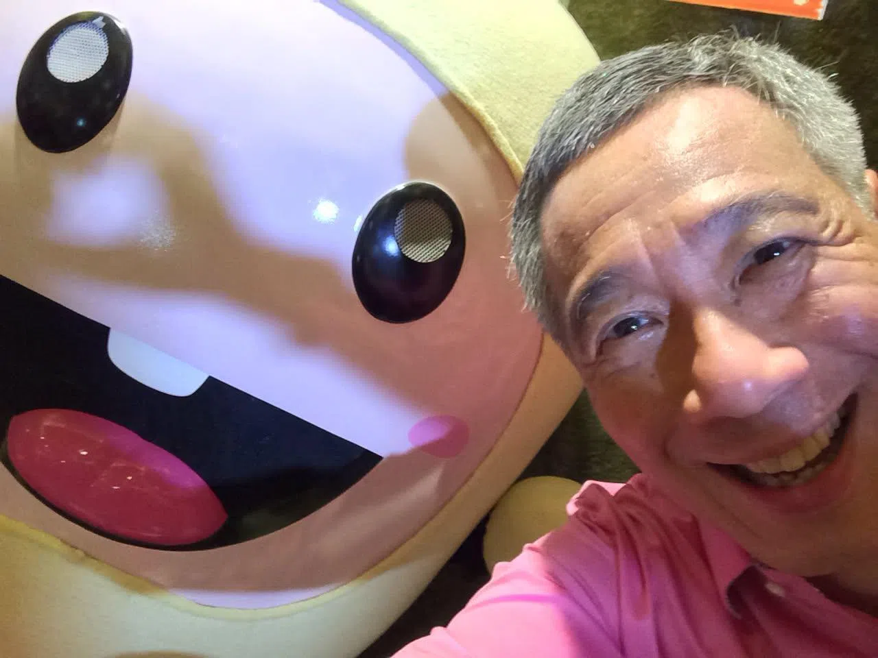 2014年“讲华语运动”启动活动上，李资政与《联合早报》旗下学生刊物《小拇指》的吉祥物自拍合影。李资政说，华语在本地日益普及，多数国人具备双语能力，但“学如逆水行舟，不进则退”，语言学习仍须持续。（取自李资政脸书）