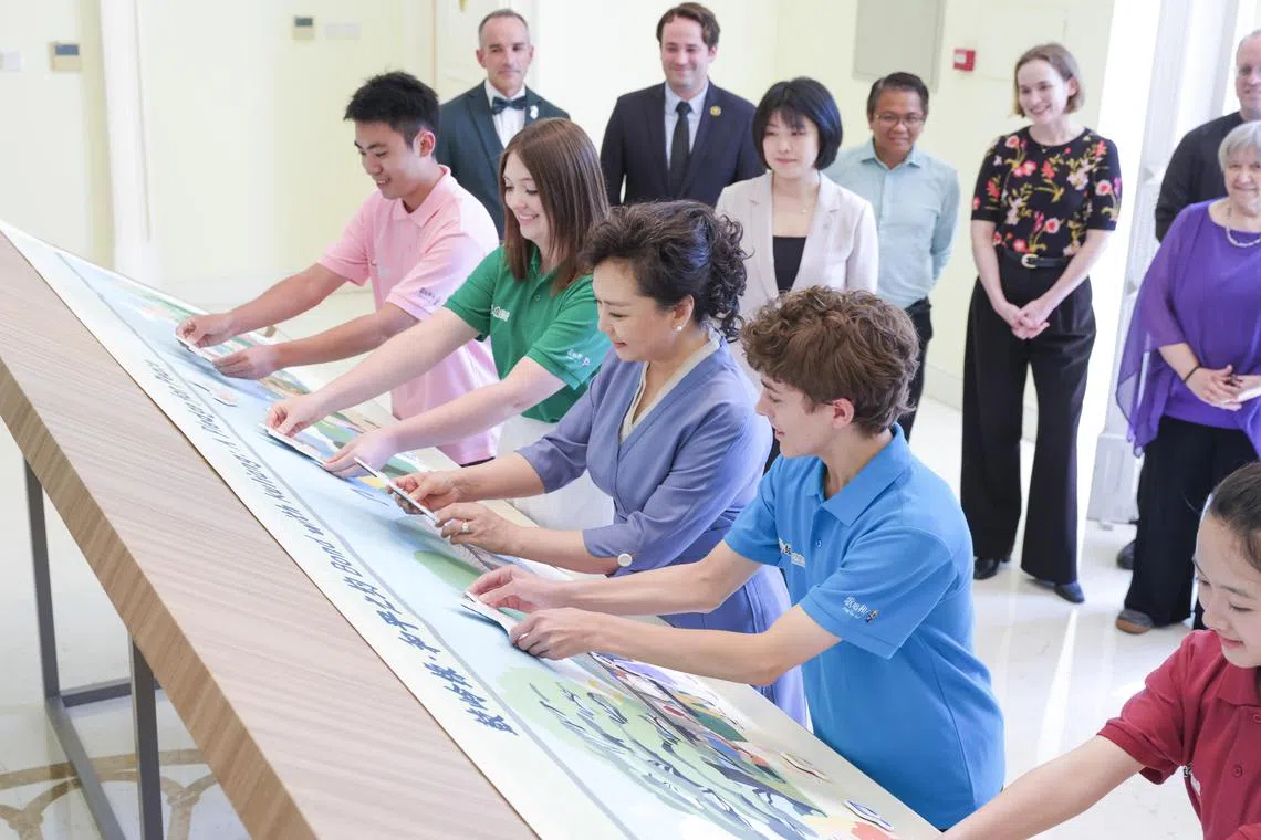 中国国家主席习近平夫人彭丽媛（右三）在全国对外友协出席2025年“鼓岭缘”中美青少年联谊活动，与中美青少年交流互动。（新华社）