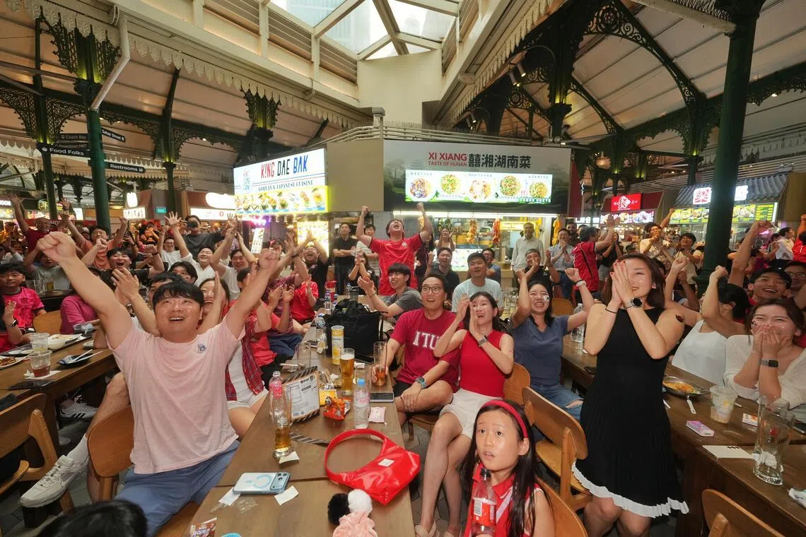 有不少穿着红色上衣的韩国球迷，聚集在老巴刹免费观赏球赛直播。（谢智扬摄）