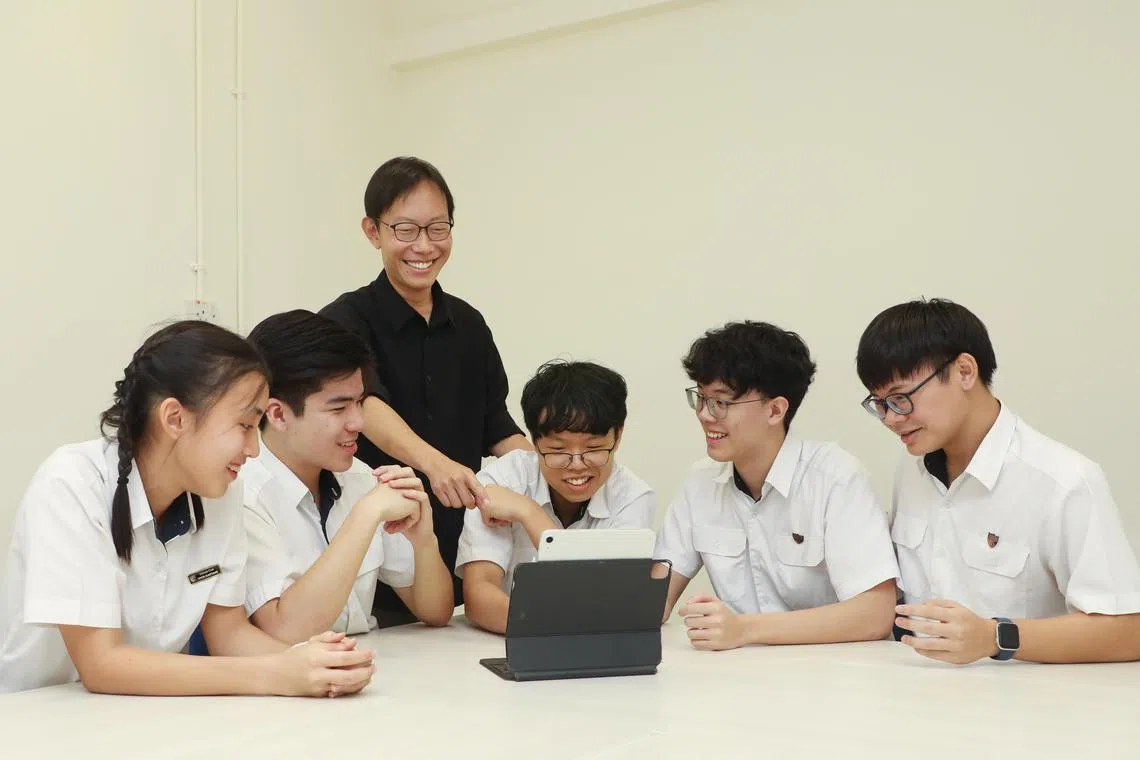 
来自英华初级学院二年级的郑紫恩（左起）、庄铠耀、李嘉乐、司徒仁凯和黄耀庆，是首批受新评分制度影响的学生。他们去年在老师冯振坚（后排）的指导下完成专题作业，推出了一款名为“SG KindActs”的手机应用，鼓励青少年持续参与志愿服务，加强与社区联系。（张恺恩摄）