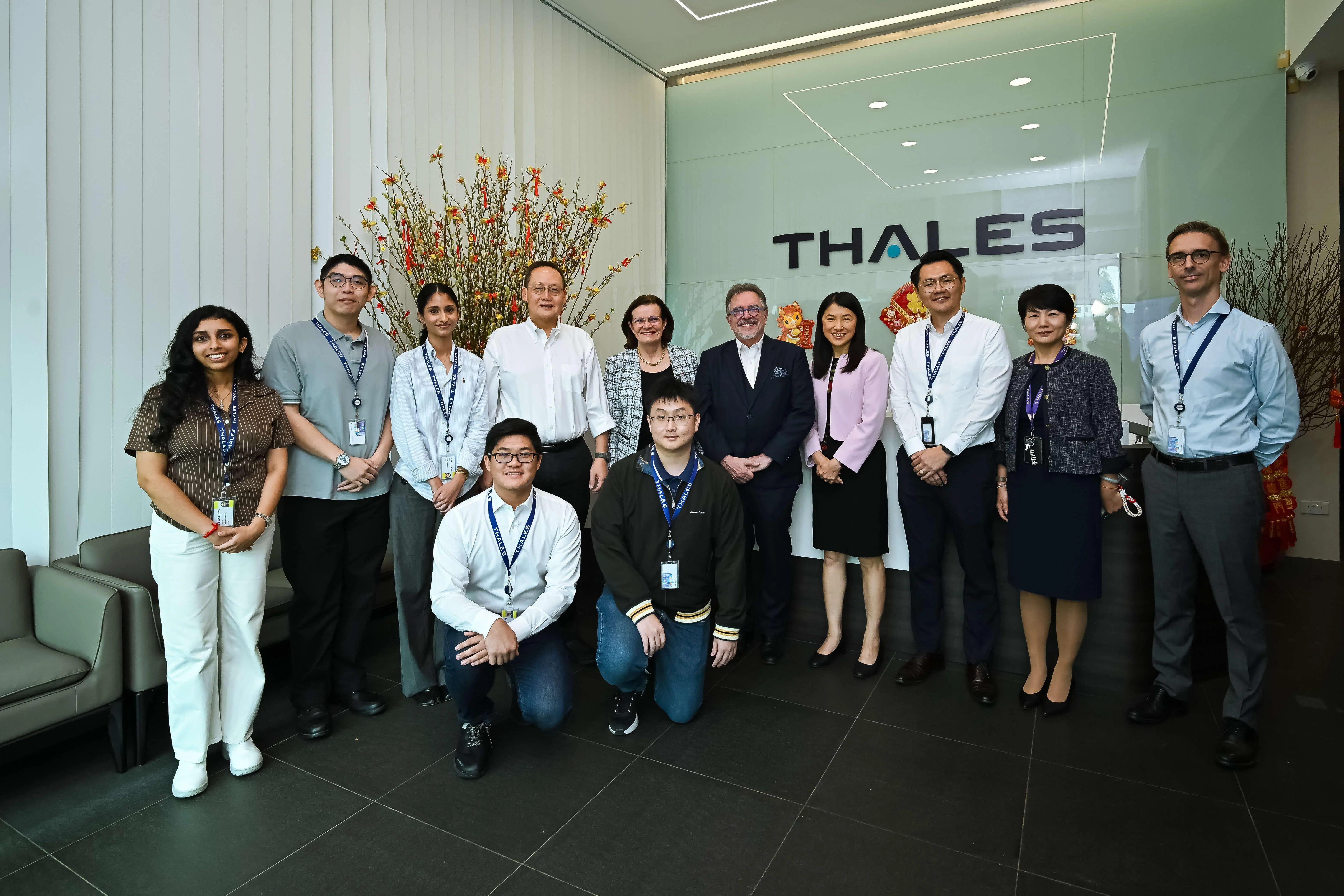人力部长陈诗龙医生（后排左四）星期五走访法国科技公司泰雷兹在樟宜北坡的办公室，并与公司管理层和参与毕业生行业见习计划的见习生合影。（人力部提供）