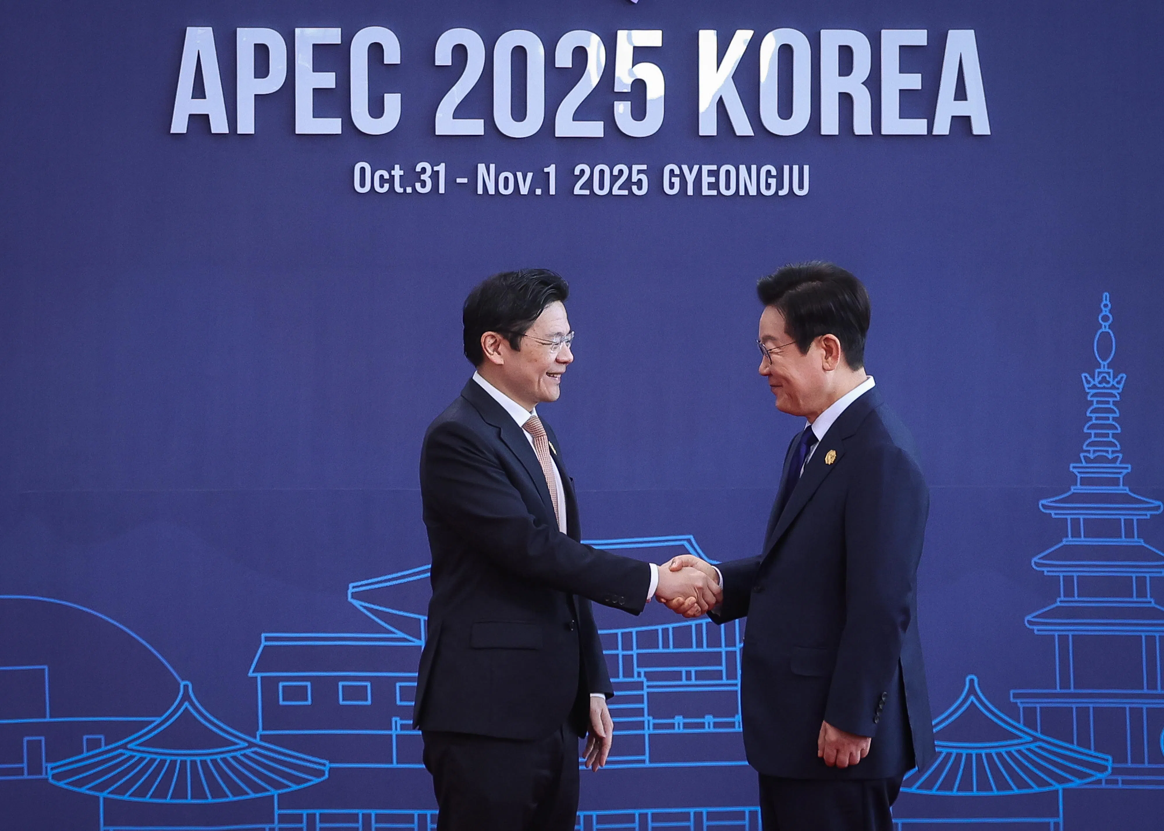 APEC经济领导人会议星期五于韩国庆州市和白会展中心正式开幕，韩国总统李在明（右）在会议开始前迎接与会嘉宾，与我国总理兼财政部长黄循财握手寒暄。（数码发展及新闻部提供）