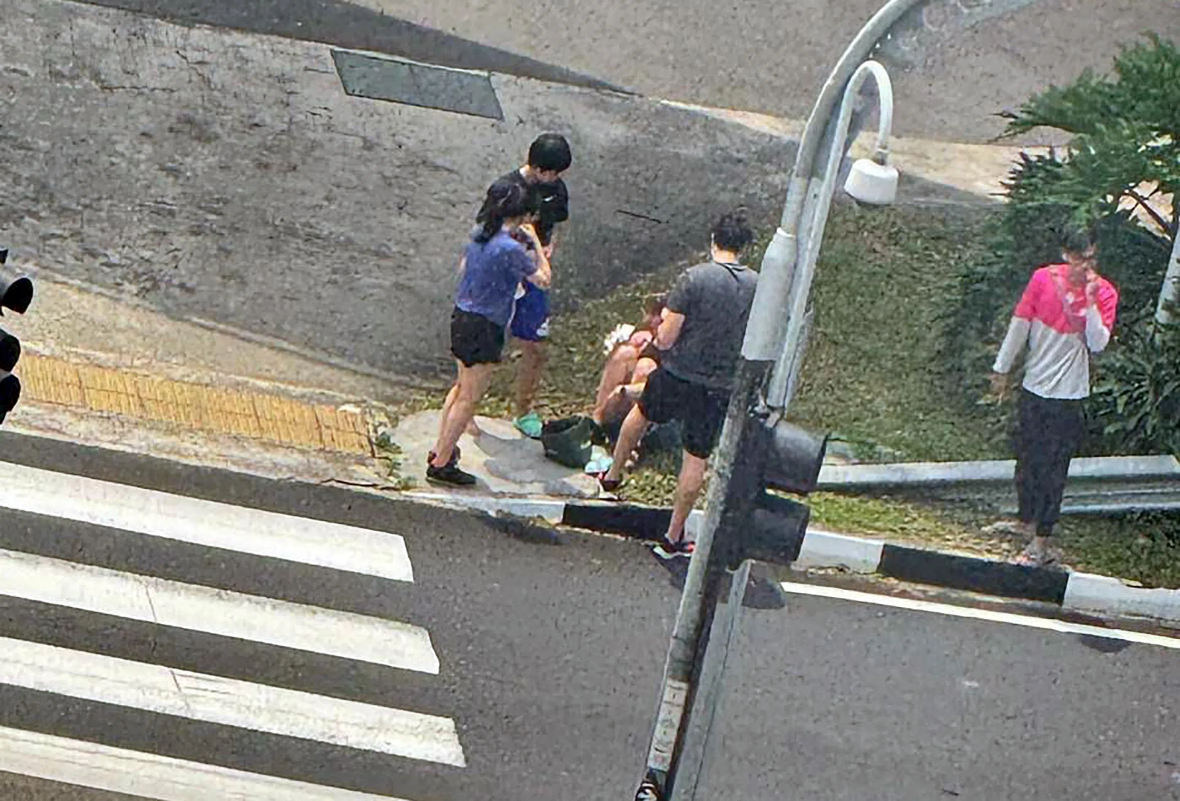 伤者坐路边等候救援。（读者提供）