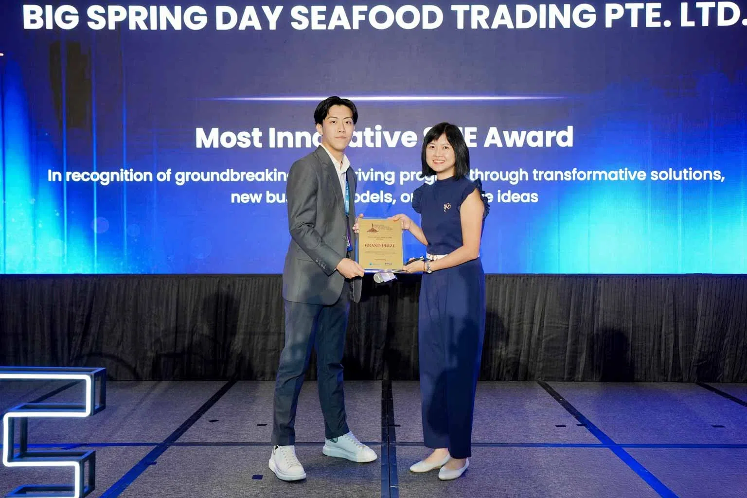 《联合早报》副总编辑洪奕婷（右）为昇原鱼丸批发商董事林德成（左）颁发“最具创新力中小企业奖”。（蚂蚁国际提供）