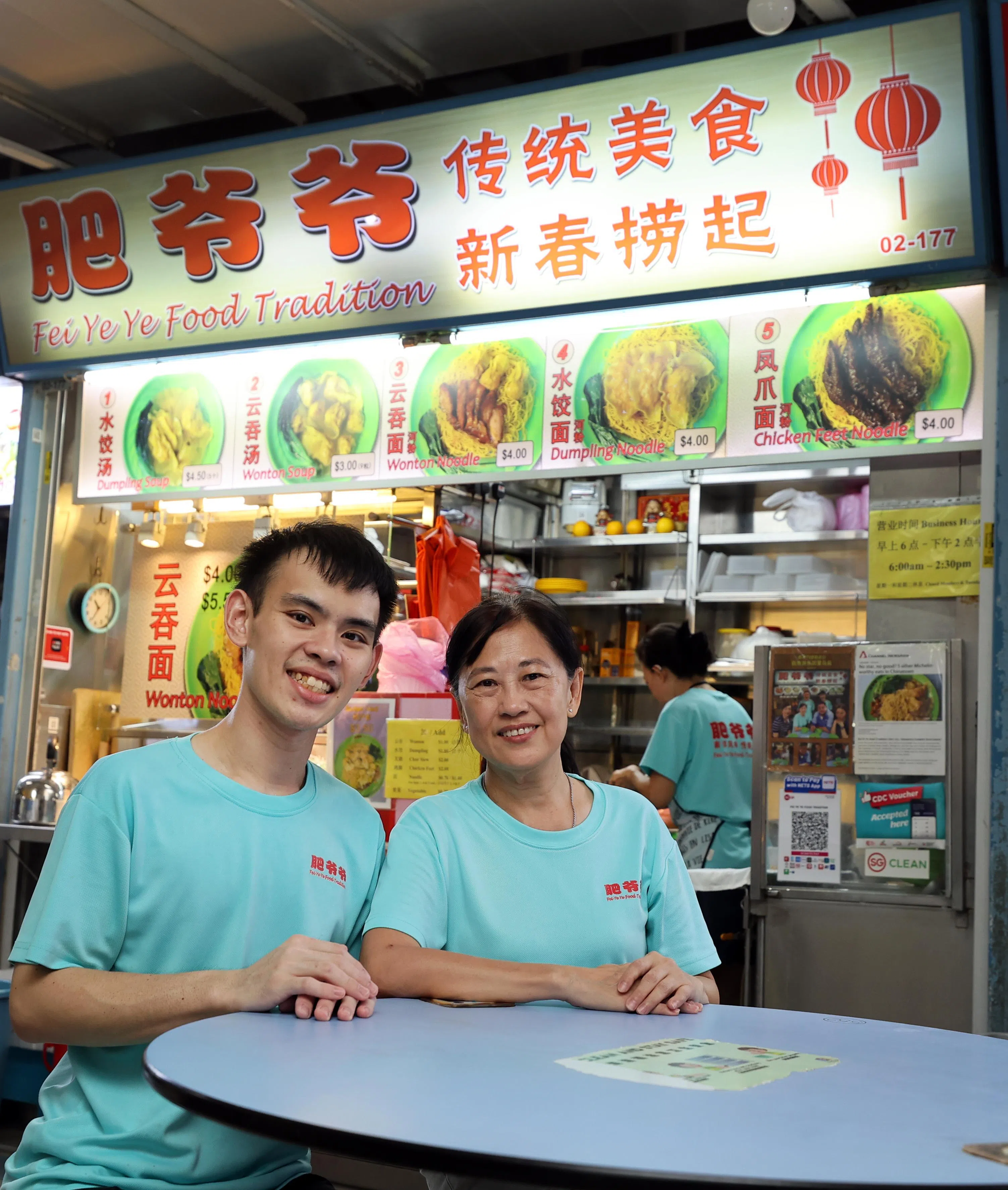 在牛车水大厦熟食中心售卖云吞面的“肥爷爷传统美食”，是首批加入商贩协会的摊贩，由吴嘉俊（左起）与母亲梁素薇共同经营。（萧紫薇摄）