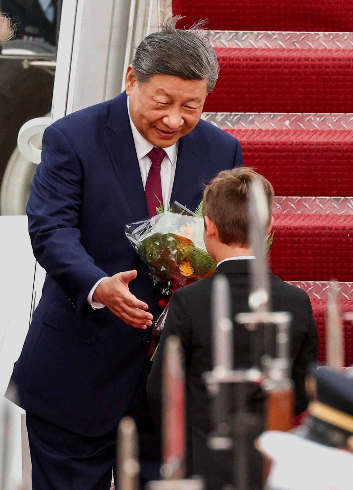 中国国家主席习近平当地时间9月23日抵达美国马里兰州安德鲁斯联合基地，展开国事访问。他接过鲜花后，微笑着向献花男孩伸出右手。（路透社）