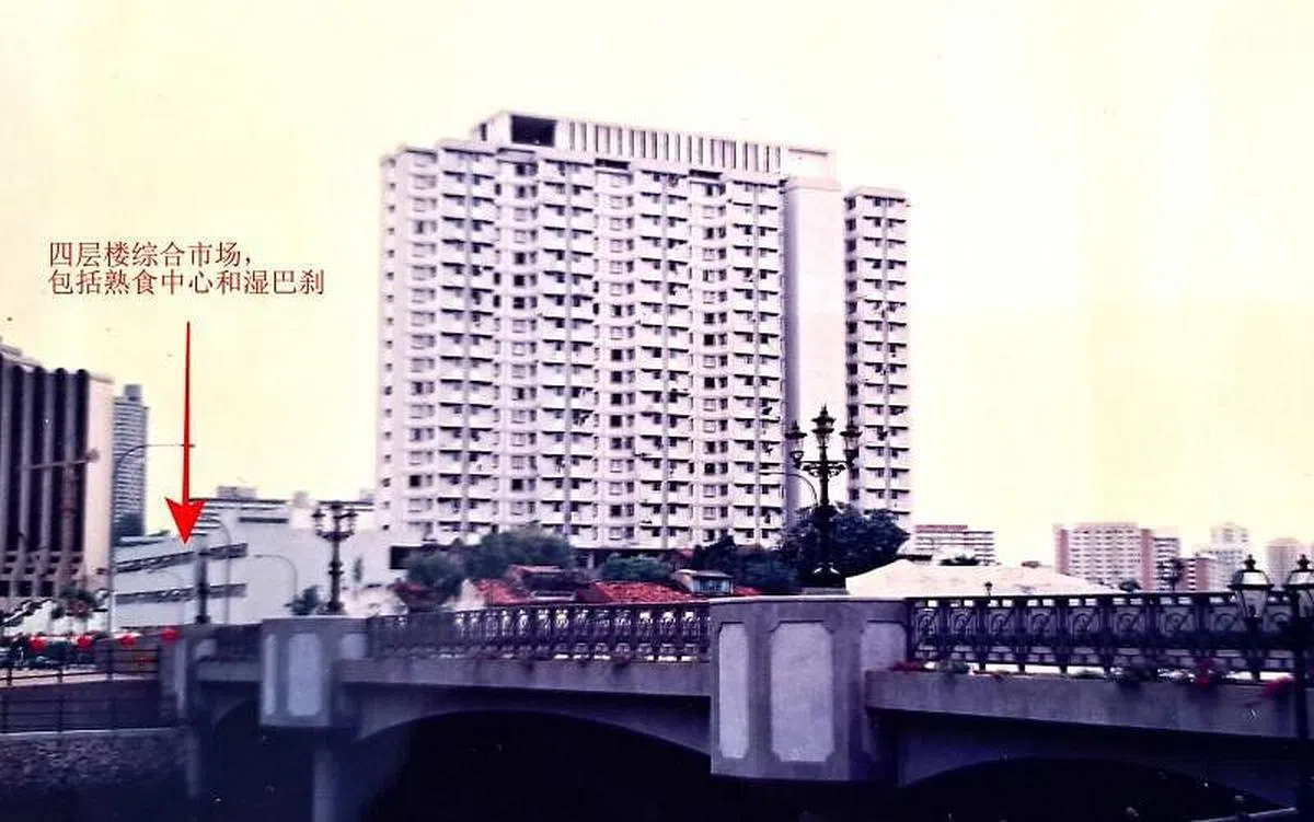 1970年代新巴刹原地兴建临时组屋，照片中新加坡河畔的一房式租赁组屋的一到四楼为综合市场与巴刹，拆除后兴建克拉码头Clarke Quay Central商场。