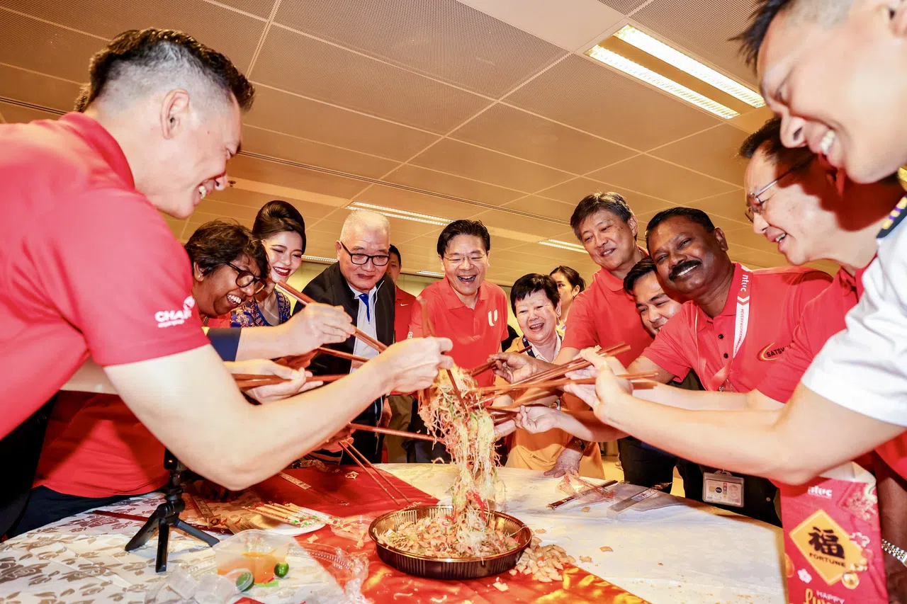 1月28日（大年除夕），黄循财总理（左五）连同全国职工总会秘书长黄志明（右五）到樟宜机场和值班员工一起捞鱼生。（陈斌勤摄）