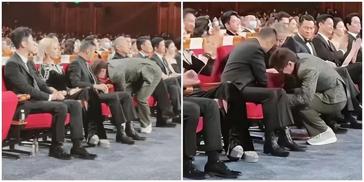 成龙要就坐时，发现椅子打不开，于是蹲下修理椅子，惹得旁边的陈道明和张涵予都转身关注。（互联网）