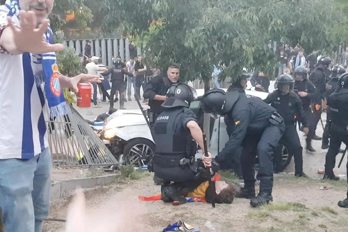 镇暴警察在场协助被汽车撞倒的一名球迷。（路透社）