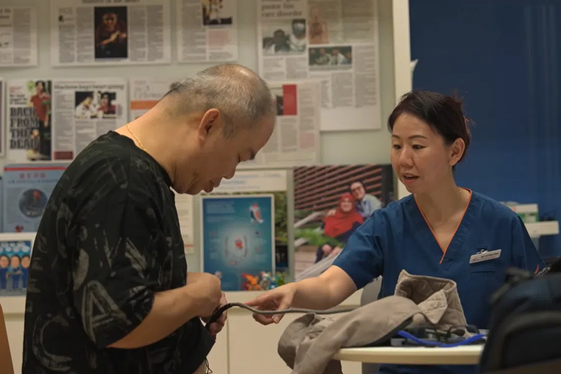 负责人工心脏使用培训的临床协调员郑慧敏（右）为郑佑鸣（左）检查机器。（视频截图）