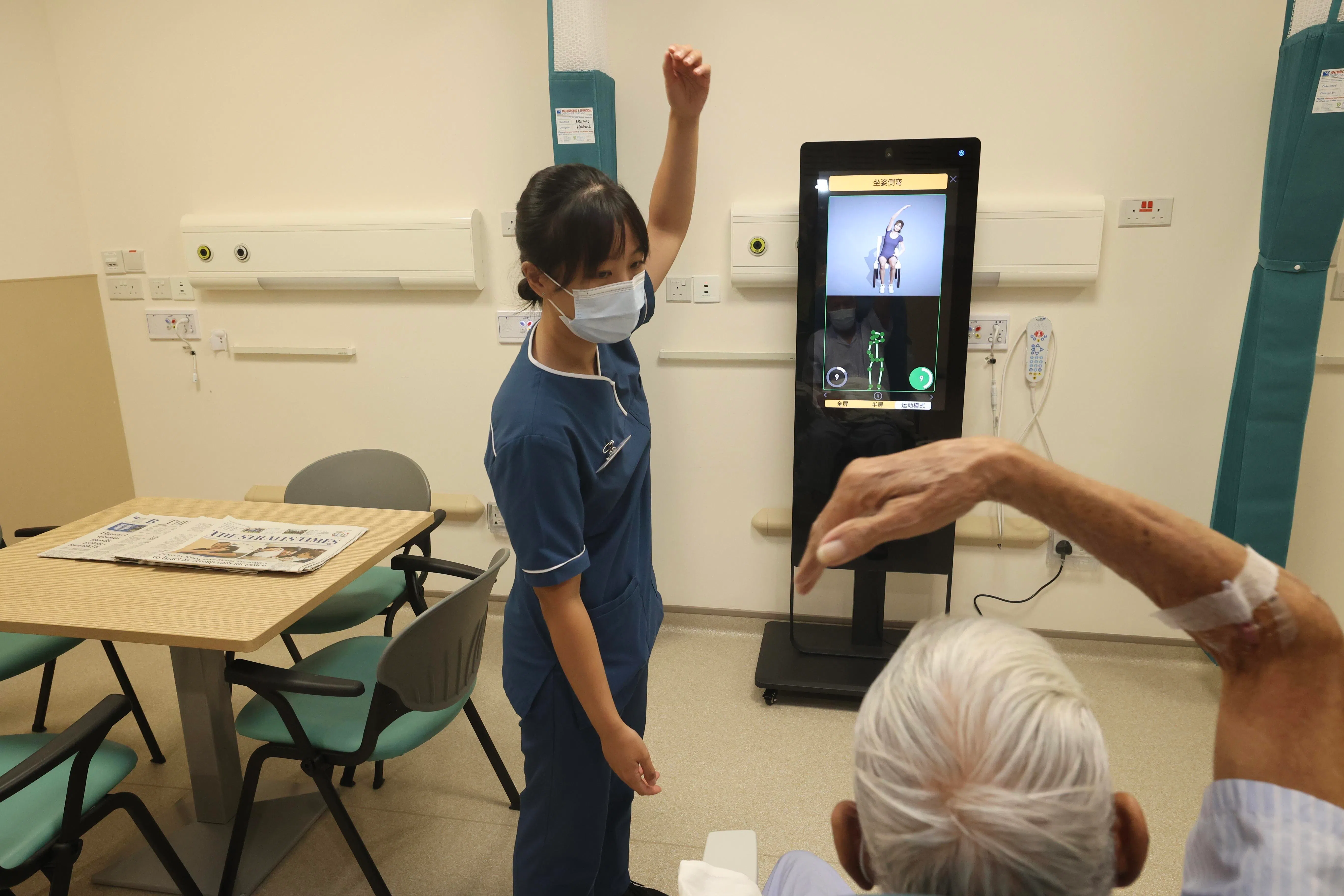 邱德拔医院急诊部高级护士陈欣仪利用病患候诊时间，引导他们做运动。（邝启聪摄）