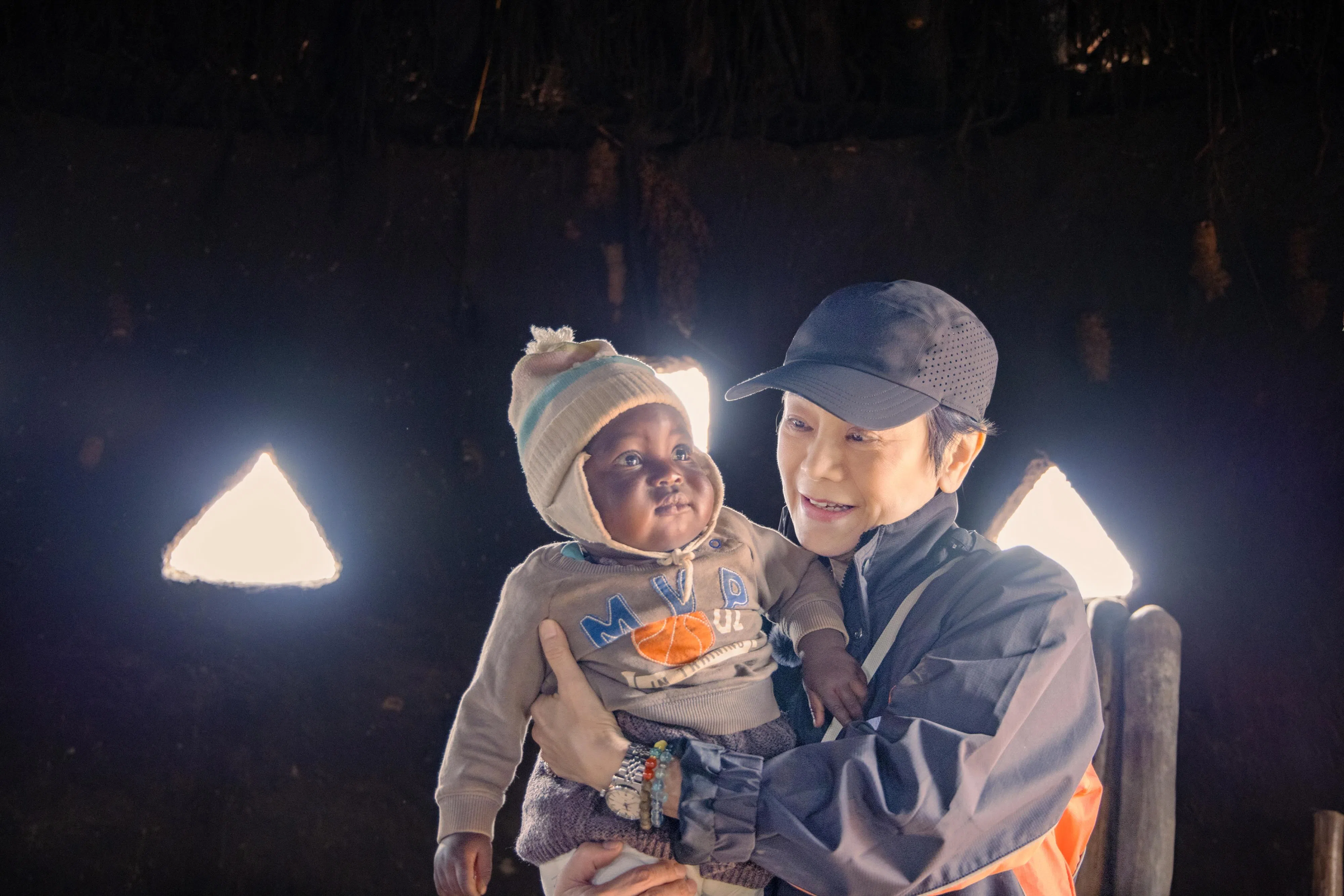 张艾嘉在赞比亚探访单亲妈妈时，为宝宝煮营养粥亲喂宝宝。（世界宣明会提供）