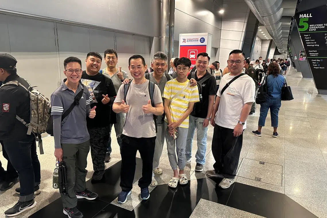 清晨排队等候接驳巴士入场参观航空展的人潮中，38岁巴士车长蒋耀宗（左一）与同事一早到场，只为抢先入场观赏飞机与飞行表演。（林煇智摄）