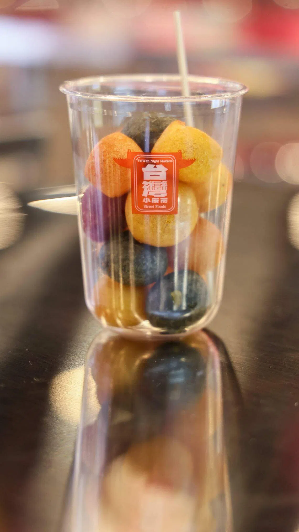 地瓜球因加入红番薯、竹炭和抹茶等形成不同颜色。除了原味，也可撒上花生粉、梅子粉、可可粉或胡椒粉。（卓祾祎摄）