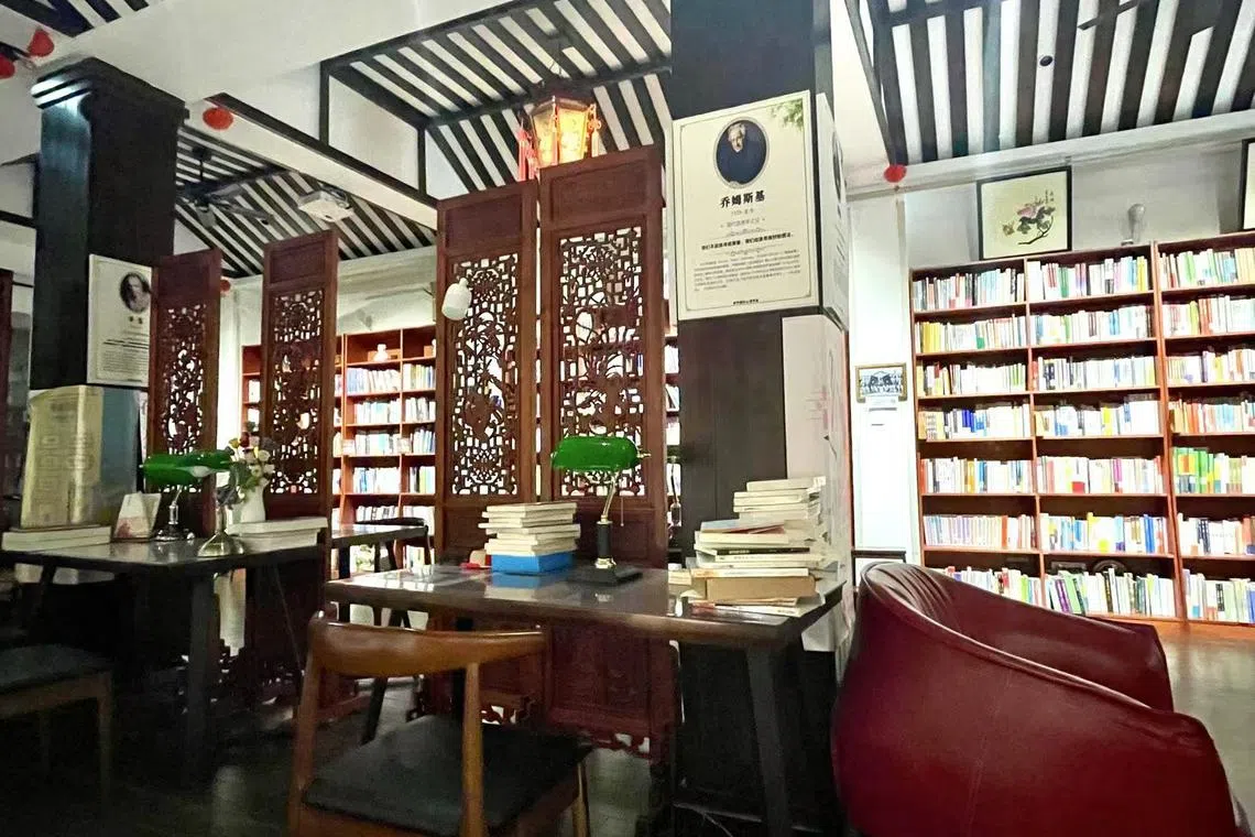 书店空间很深，中间用镂空屏风隔开，木桌、台灯、沙发……给人通透、舒适感。（张志华摄）