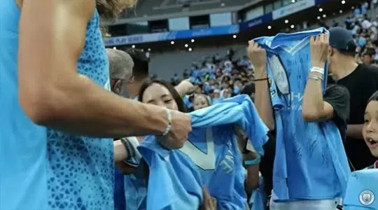 全智贤发现有摄影机在拍摄，害羞得赶紧拿球衣遮脸。（互联网）