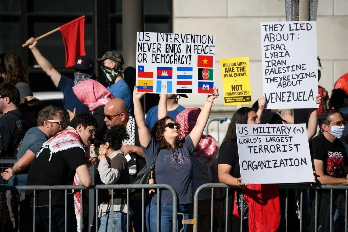 美国民众星期天在得克萨斯州休斯顿举行示威，抗议美国接管委内瑞拉。示威者高举标语牌称，“美军是世界上最大的恐怖组织”，并指“美国对外国的干预永远无法带来和平或民主”。（彭博社）