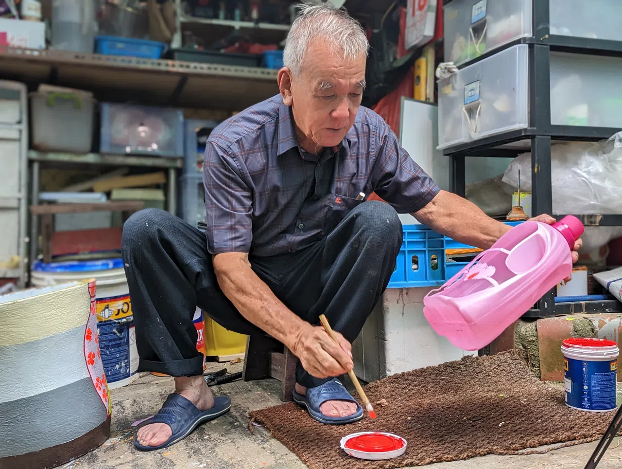 社区花园内外的回收塑料瓶花盆，多出自谢木顺的巧手。（杨雯婷摄）
