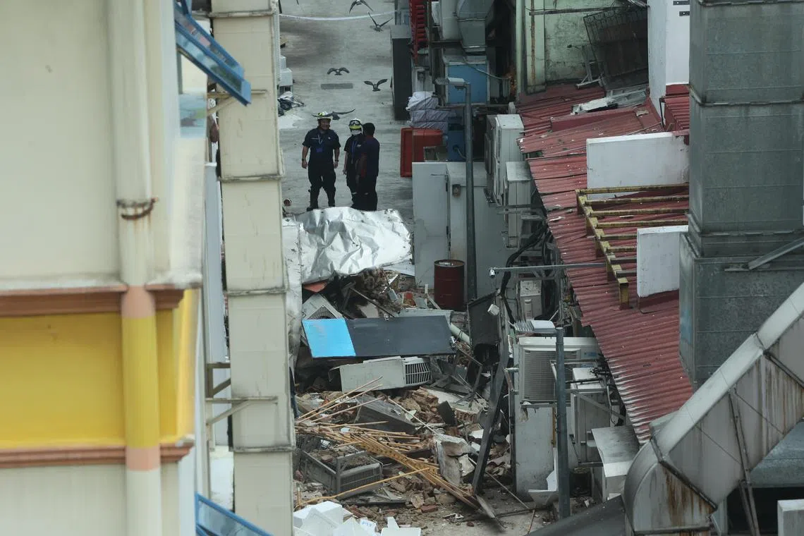 后巷对街可见，店屋后方坍塌的墙体残骸堆满巷子。（陈斌勤摄）