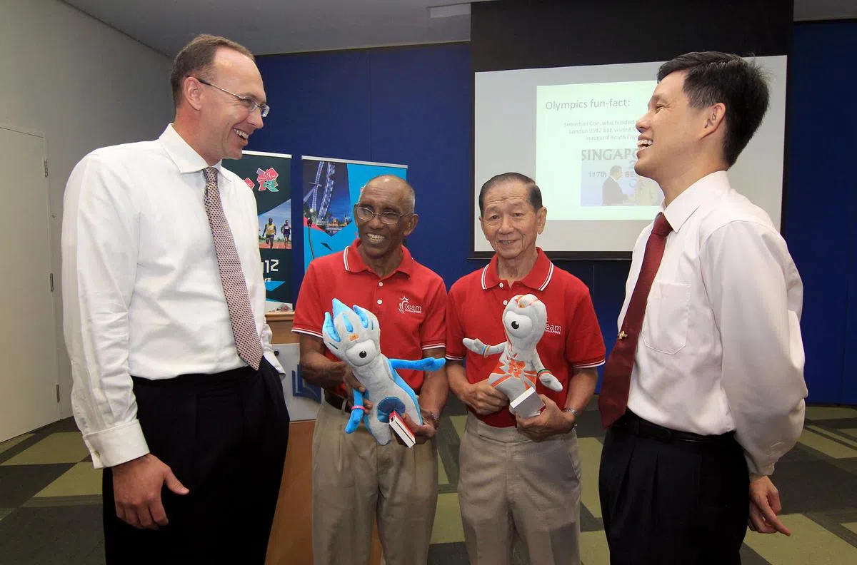 2012年伦敦奥运会开幕的前一年，全球驻外的英国最高专员公署与大使馆举办了倒数活动。英国驻新加坡前最高专员菲利普森（左一）和新加坡时任社会发展、青年及体育部（社青体部）代部长陈振声少将（右一），与手握2012年伦敦奥运会吉祥物的本地体坛名宿古那南及谢文龙（右二）谈笑风生。（档案照）