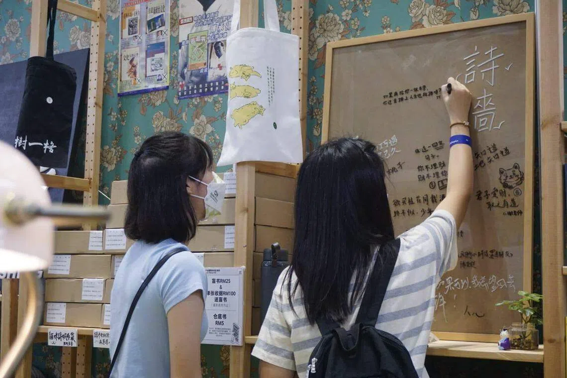 大将出版社在吉隆坡海外华文书市展摊内设诗墙，邀请公众写上自己喜欢的诗句。（大将出版社提供）
