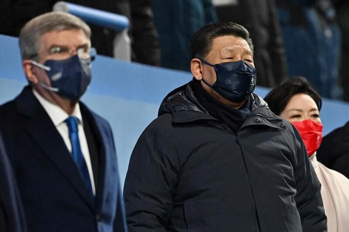 中国国家主席习近平（中）与夫人彭丽媛（右）出席北京冬奥会开幕式，图中左侧的是国际奥委会主席巴赫。（法新社）