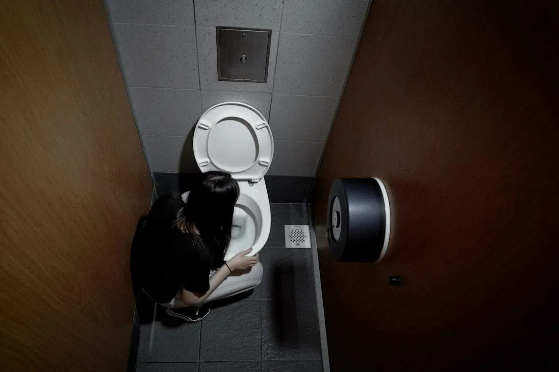 厕所是伍靖敏的避难所，她在感到焦虑时会躲进厕所里默默哭泣，极度焦虑时甚至会呕吐。（视频截图）