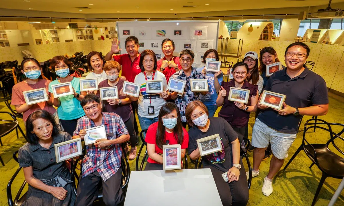工作坊顺利结束后，参与活动的读者纷纷高兴地展示自己的作品，并跟指导他们进行图像转印的早报高级摄影记者蔡家增（最后排左一）和梁麒麟（左二）一同合影留念。（叶振忠摄）
