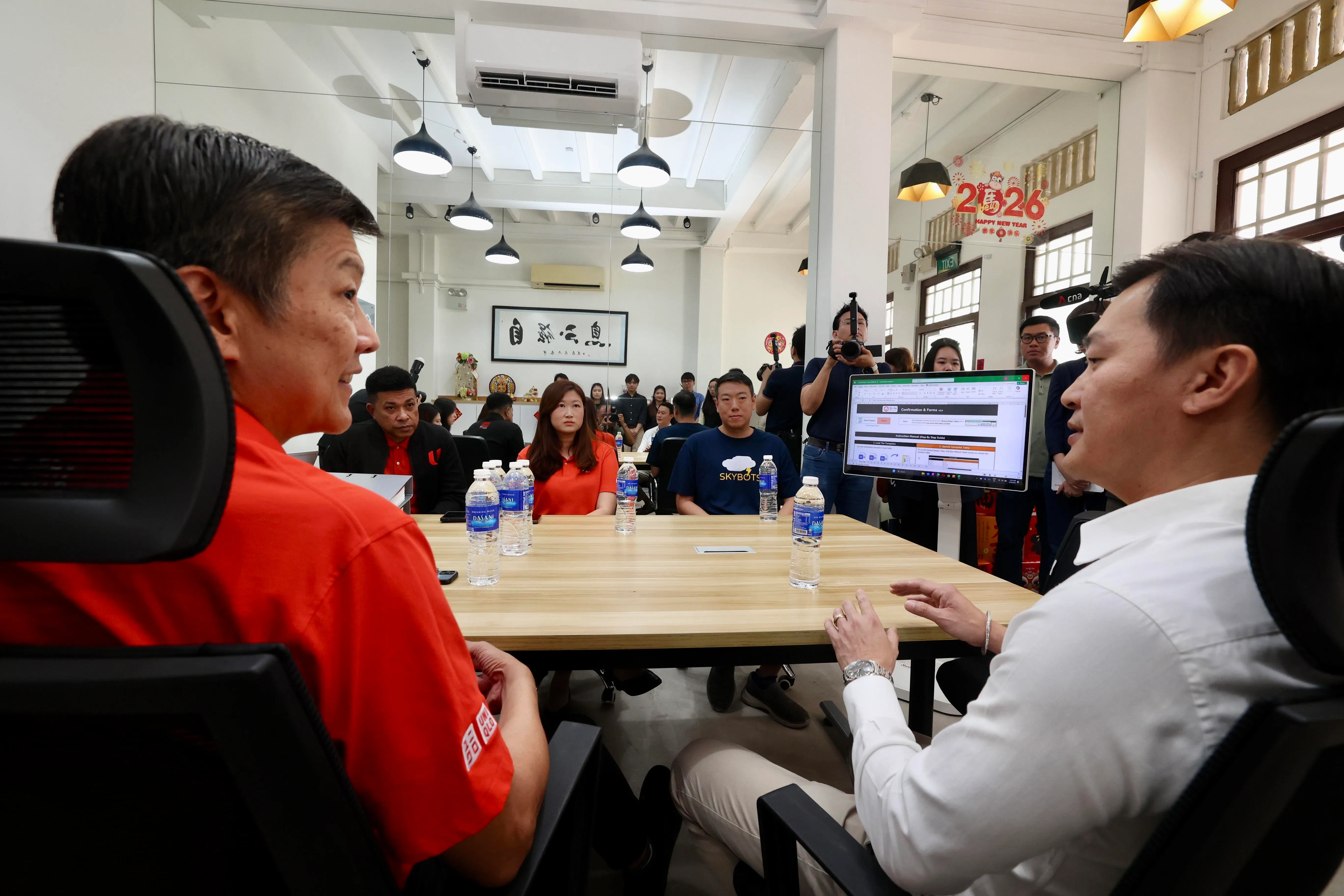 职总秘书长黄志明（左）听取鑫计管理合伙人张达鑫（右）讲解公司如何通过企业培训委员会补助金引入人工智能工具。（邝启聪摄）