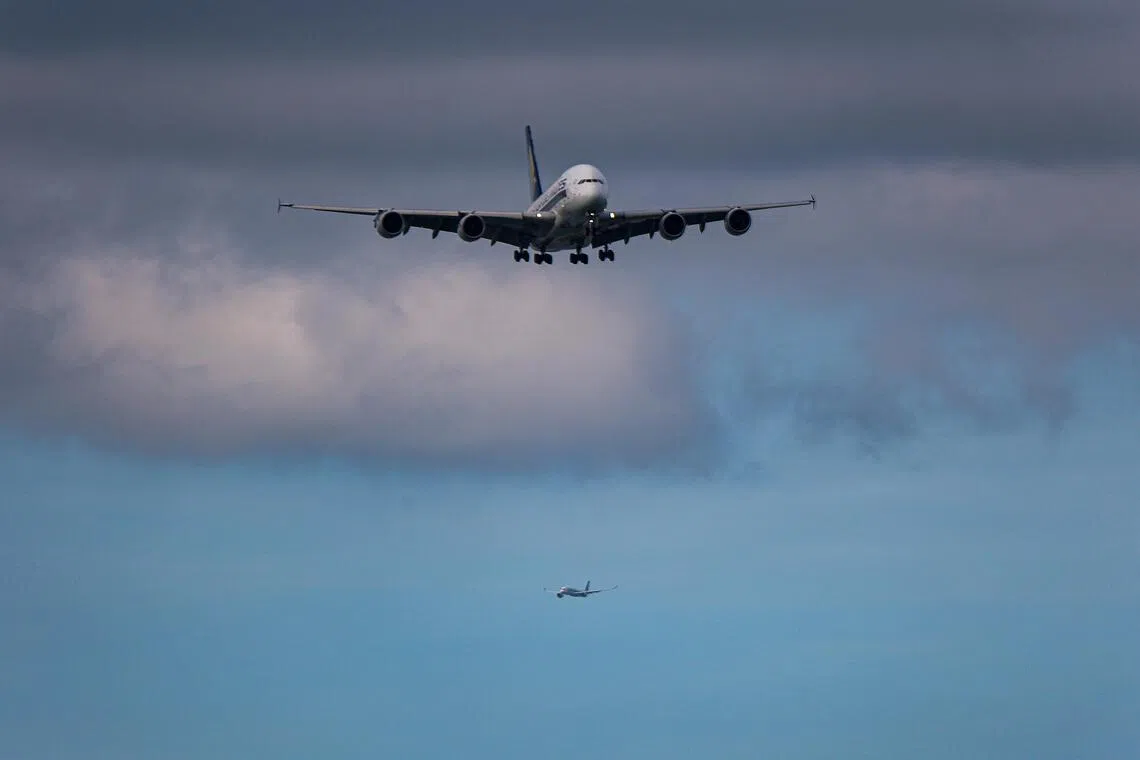 两架同向而行的飞机，先后掠过同一片天空。（关俊威摄）
