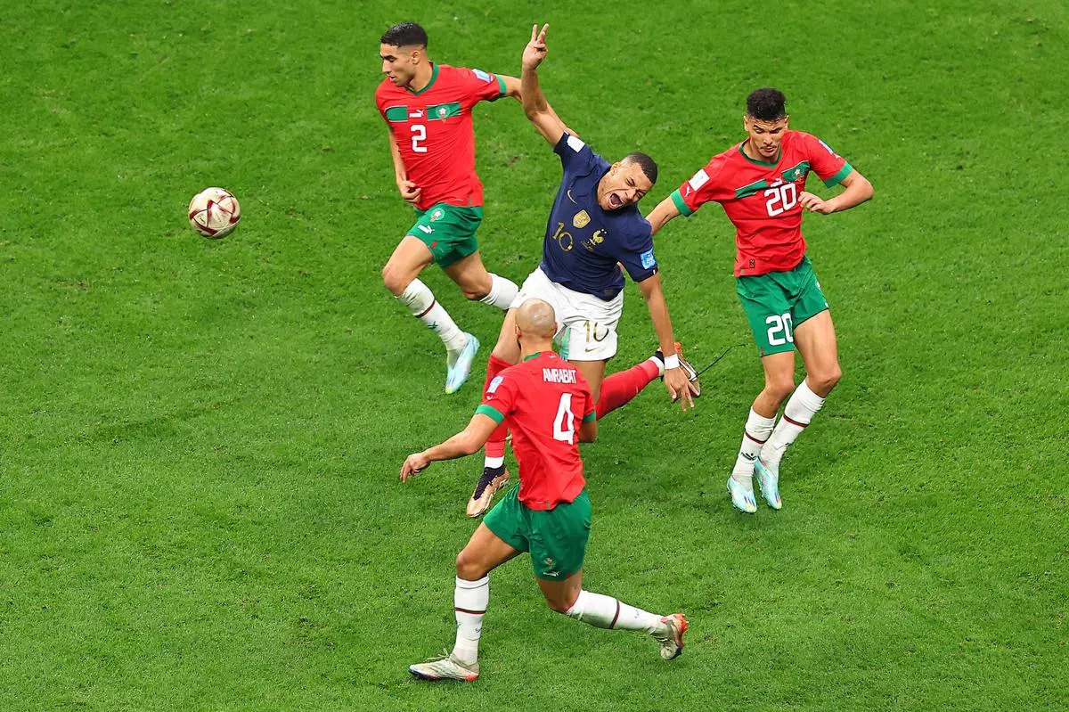 姆巴佩（中）全场比赛都遭遇摩洛哥多名球员盯防夹击。（新华社） 