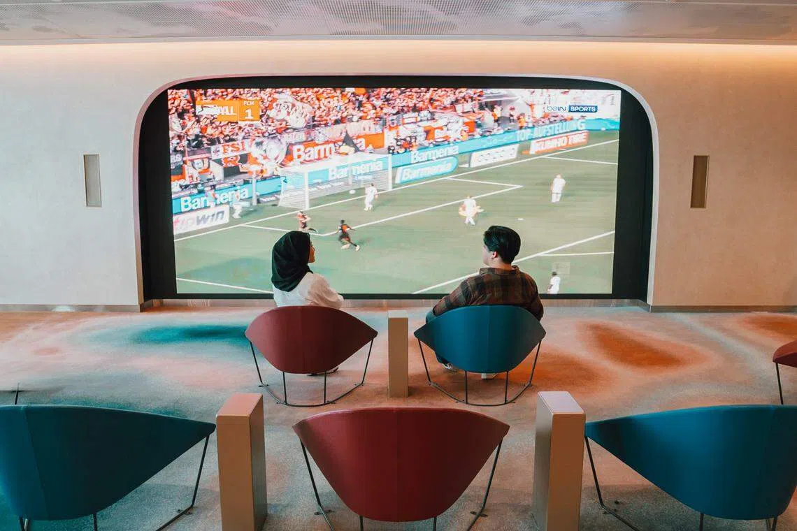 在过境区，乘客可通过巨型LED屏幕观看最新的体育和电视节目，打发时间。（樟宜机场集团提供）