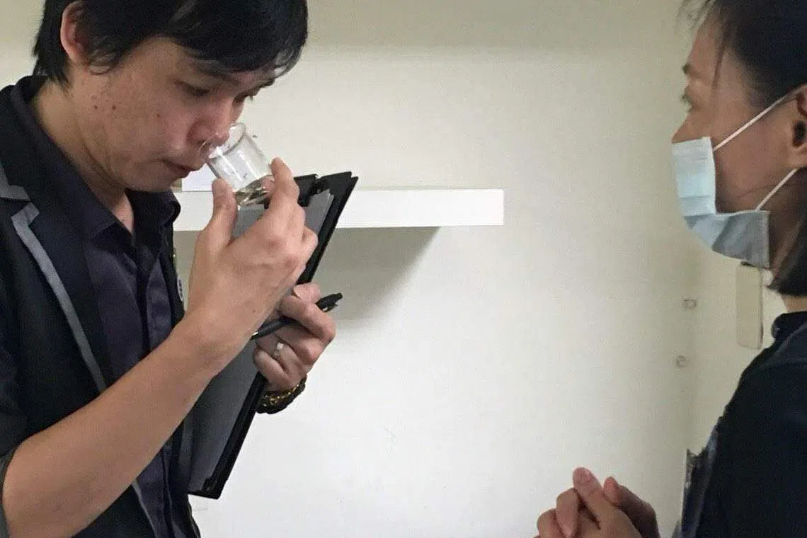 除了培训新人，郑胜中（左）还担任国际芳香治疗师学会的考官。图中为他在检查考生调配的精油。（受访者提供）
