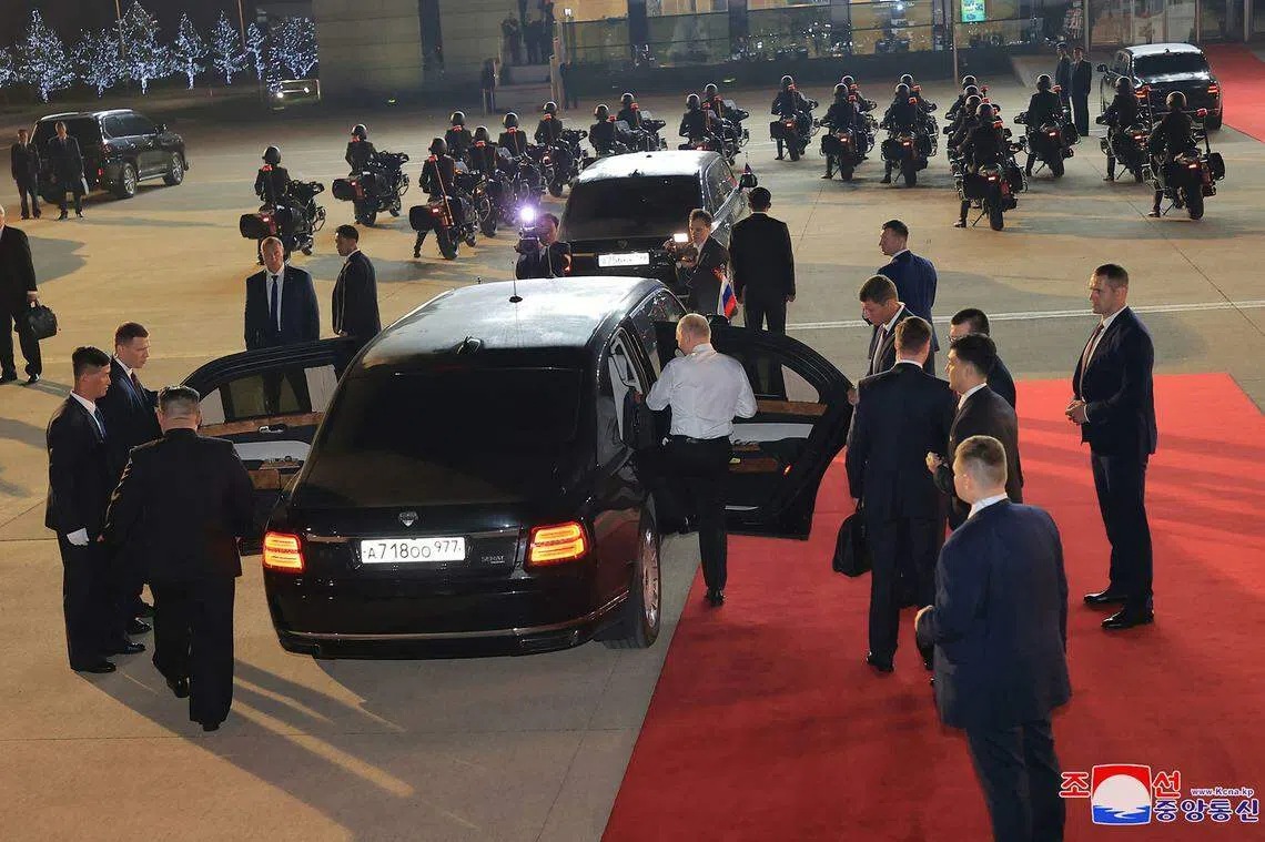 俄罗斯总统普京（身穿白衬衫者）抵达朝鲜首都平壤国际机场后，邀请苦候多时的朝鲜领导人金正恩（下左）一起登上普京的轿车。两人相互谦让主座，“车主”普京最终大动作振臂脱去外套，登上主座。图片摄于6月19日，由朝中社发布。（法新社）