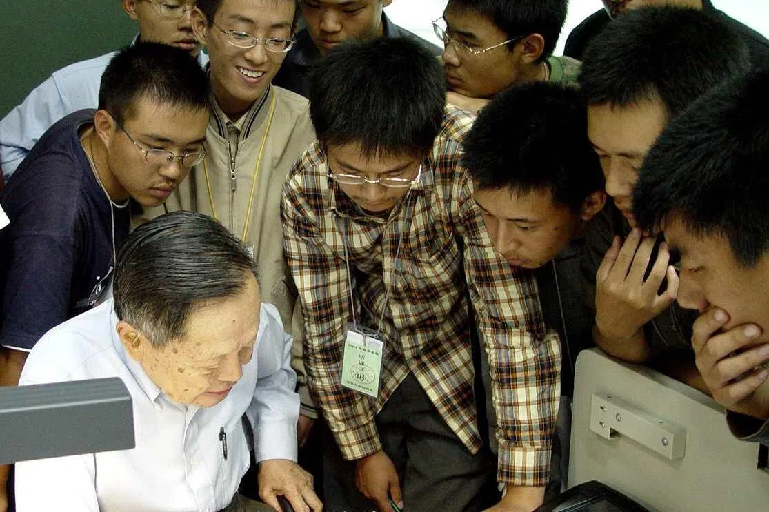 杨振宁1999年起出任清华大学教授，2003年第一任妻子杜致礼去世后，杨振宁开始在清华大学长期定居工作。图为2004年9月，他在清华大学指导本科生。（新华社）