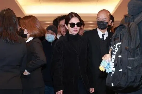 Ella（戴墨镜者）在送别良师好友不断抽泣，哀伤离场。（互联网）